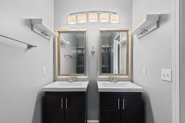 an empty room with wooden floor chandelier fan and windows