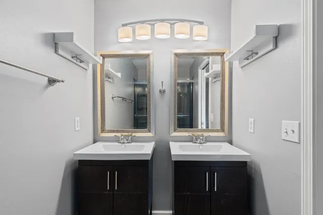 an empty room with wooden floor chandelier fan and windows
