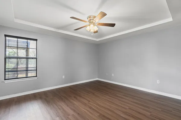 a view of an empty room and chandelier fan