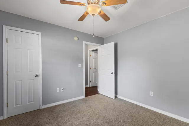 an empty room with a window and a fan