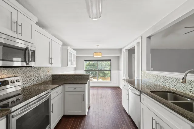 a kitchen with stainless steel appliances granite countertop a sink stove and refrigerator