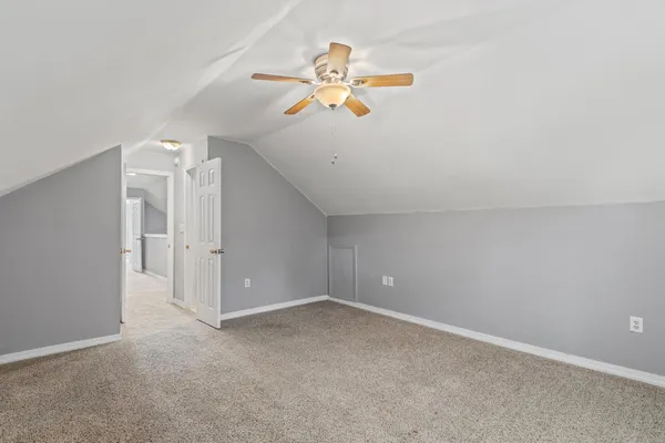 an empty room with a window and a chandelier fan