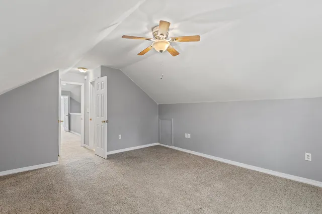 an empty room with a window and a chandelier fan
