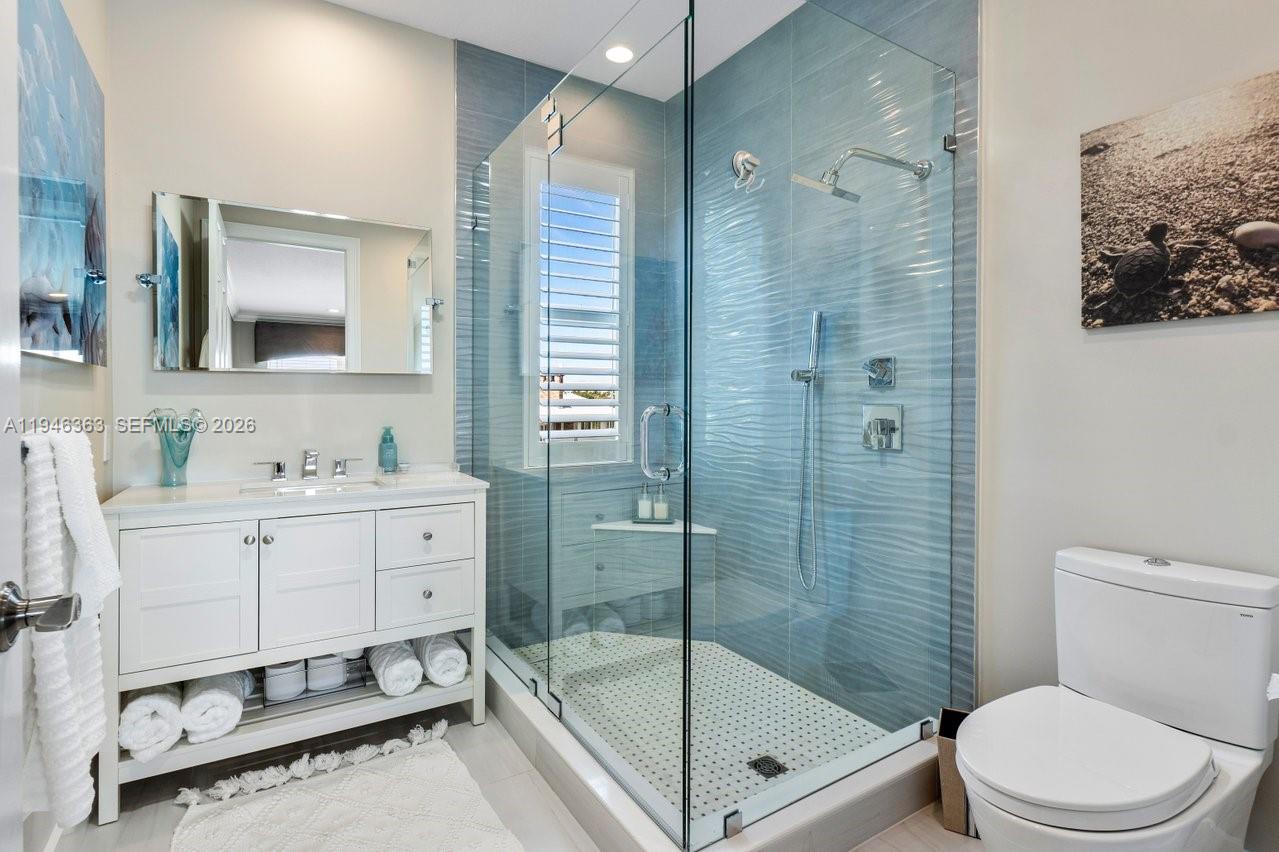 102 Xanadu Place Jupiter, FL 33477 - Photo 20 of 36 a bathroom with a sink a toilet a mirror and shower