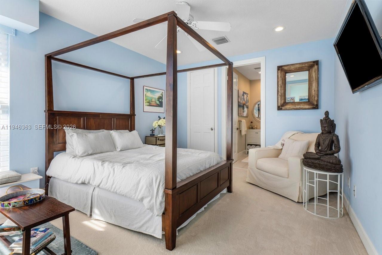 102 Xanadu Place Jupiter, FL 33477 - Photo 23 of 36 a spacious bedroom with a bed and a flat screen tv