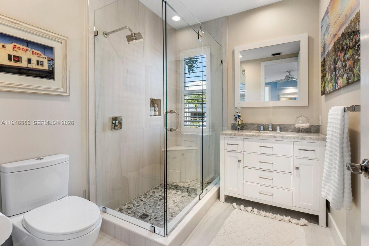 102 Xanadu Place Jupiter, FL 33477 - Photo 26 of 36 a bathroom with a granite countertop sink toilet and shower