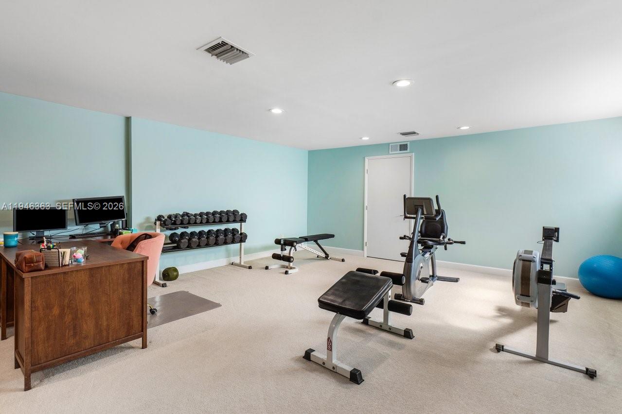 102 Xanadu Place Jupiter, FL 33477 - Photo 28 of 36 a living room with furniture gym equipment and a flat screen tv
