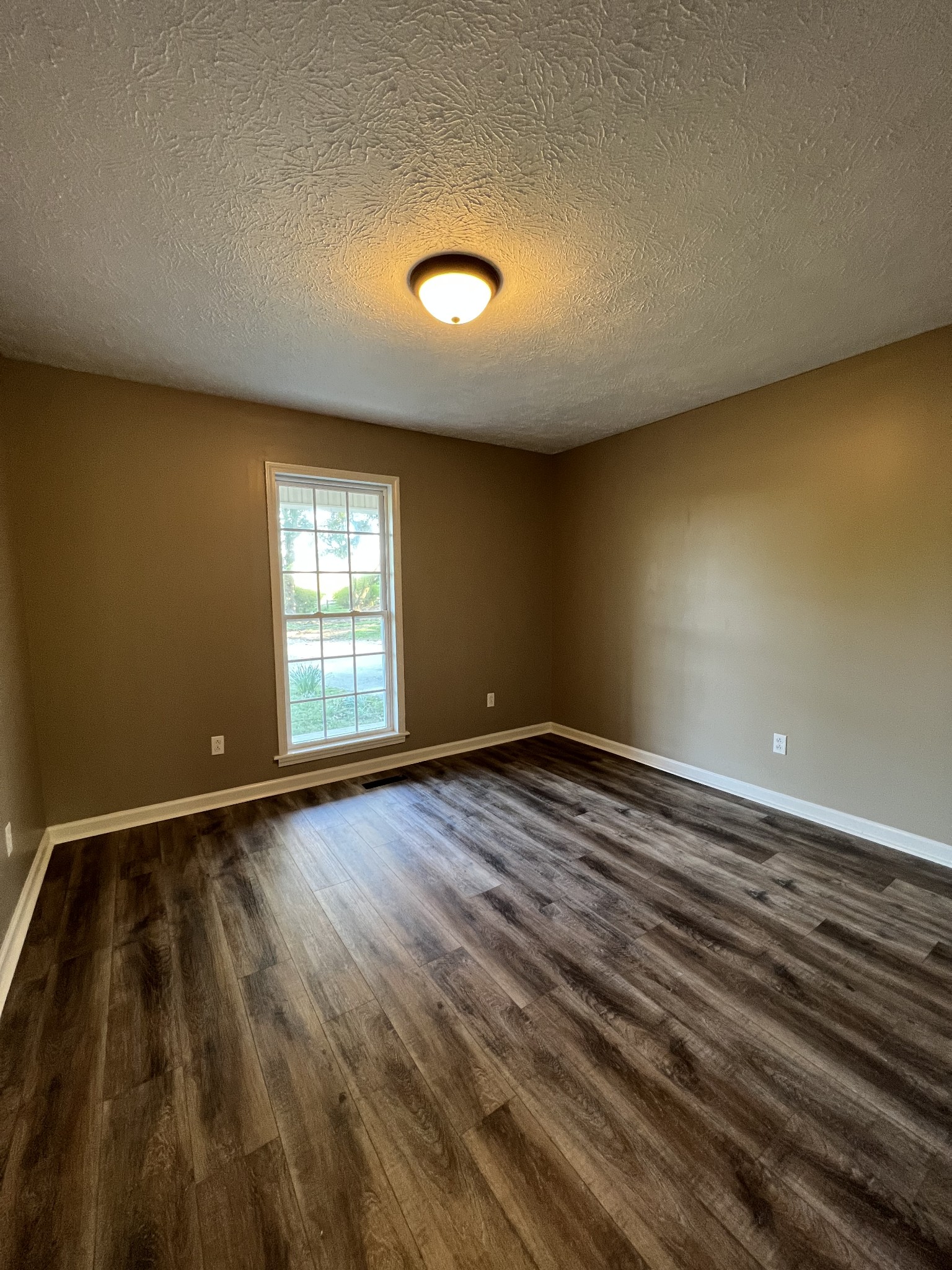 7220 McCormick Ridge Road Whitleyville, TN 38588 - Photo 6 of 9 an empty room with wooden floor and windows