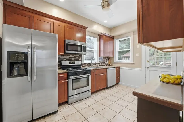 a kitchen with stainless steel appliances granite countertop a refrigerator a stove and a sink