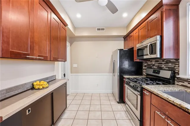 a kitchen with stainless steel appliances granite countertop a refrigerator and a stove