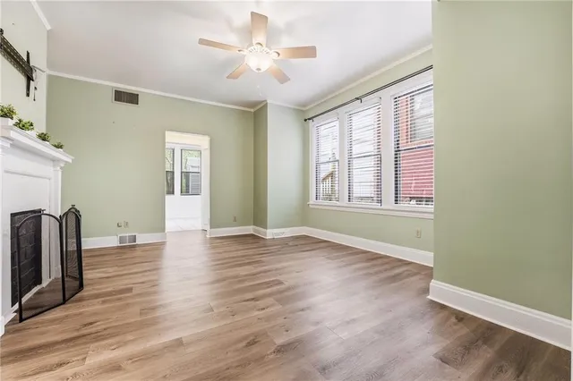 a view of an empty room with window and wooden floor