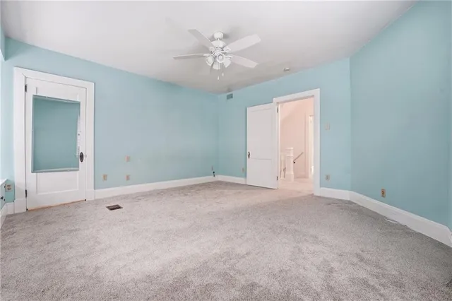 an empty room with a ceiling fan and a window