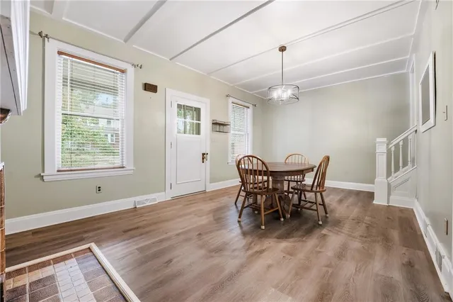 a dining room with furniture a chandelier and wooden floor