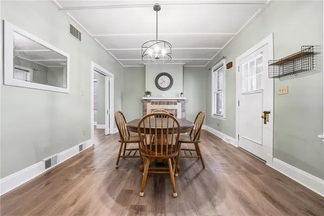 a view of a dining room with furniture a chandelier and wooden floor