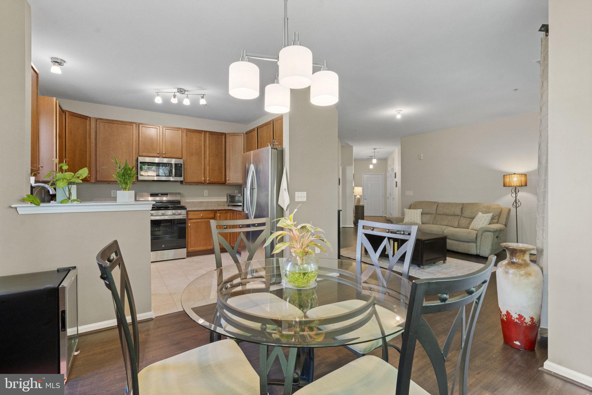 218 Timberlake Drive Ewing, NJ 08618 - Photo 7 of 30 a kitchen with stainless steel appliances granite countertop a stove a kitchen island a dining table and chairs with wooden floor
