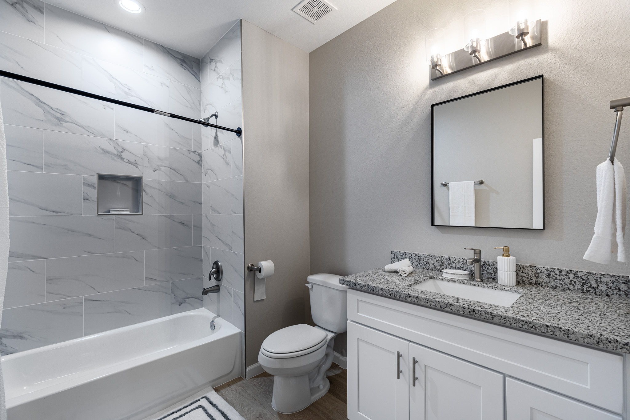 4661 Clover Street, Unit B Houston, TX 77051 - Photo 24 of 26 a bathroom with a granite countertop sink a toilet a mirror a bathtub and shower