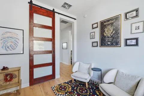 a living room with furniture and a painting on the wall