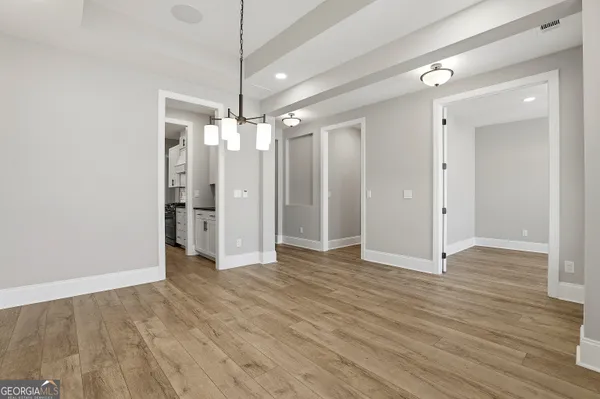 an empty room with wooden floor a fireplace and windows