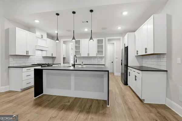 a kitchen with a stove a sink and a refrigerator