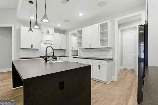 a kitchen with stainless steel appliances granite countertop a sink a stove and a wooden floors