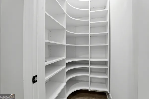 a view of a livingroom with wooden floor and a ceiling fan