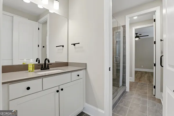 an empty room with wooden floor ceiling fan and windows