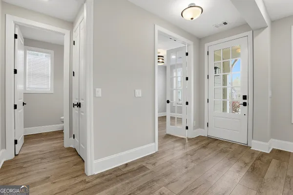 a view of empty room with wooden floor and floor to ceiling window