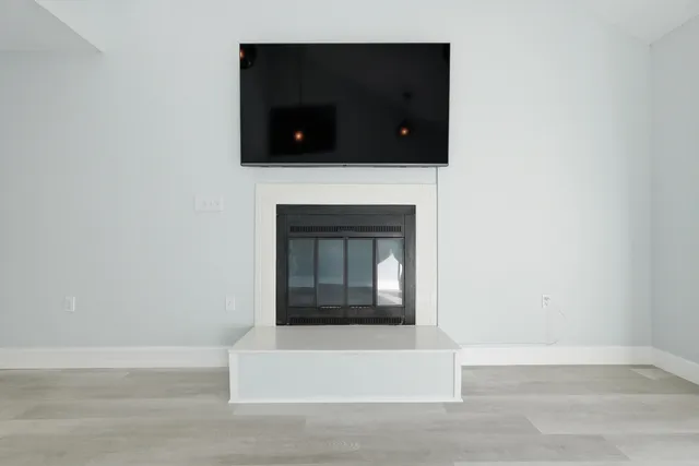 a kitchen with white cabinets stainless steel appliances and wooden floor