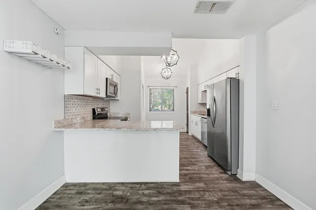 a bathroom with a granite countertop toilet a sink and a bathtub