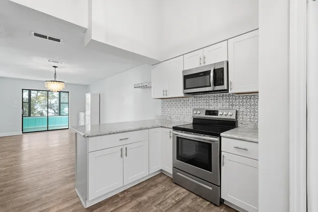a bathroom with a granite countertop sink toilet mirror and shower