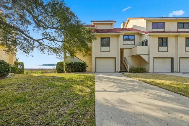 a view of a hallway with wooden floor and a bathroom