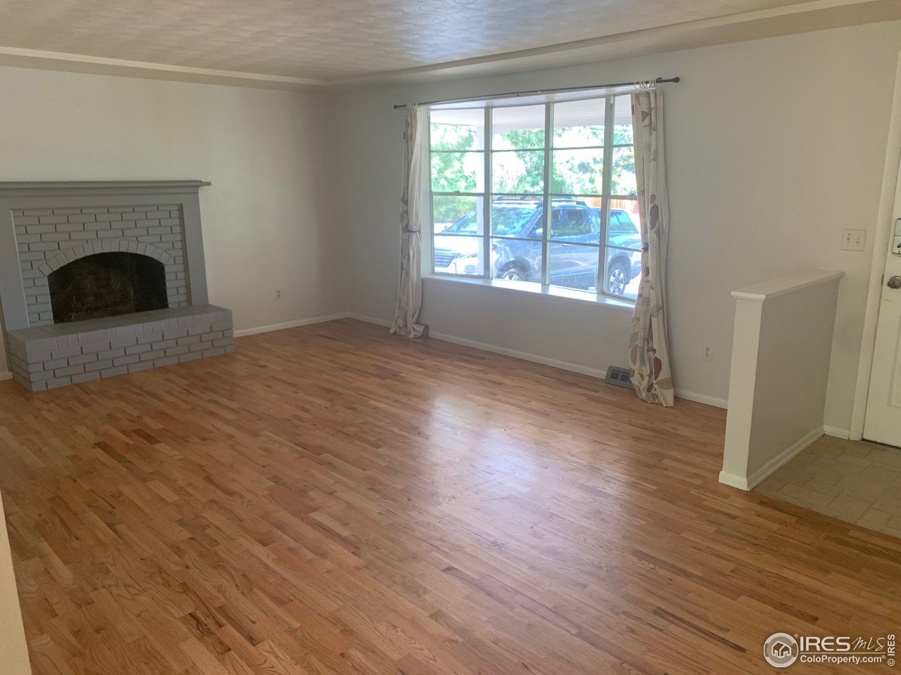 3310 Everett Drive Boulder, CO 80305 - Photo 7 of 17 a view of empty room with wooden floor and fireplace