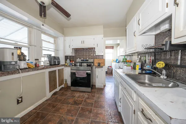 a kitchen with a sink a counter top space appliances and cabinets