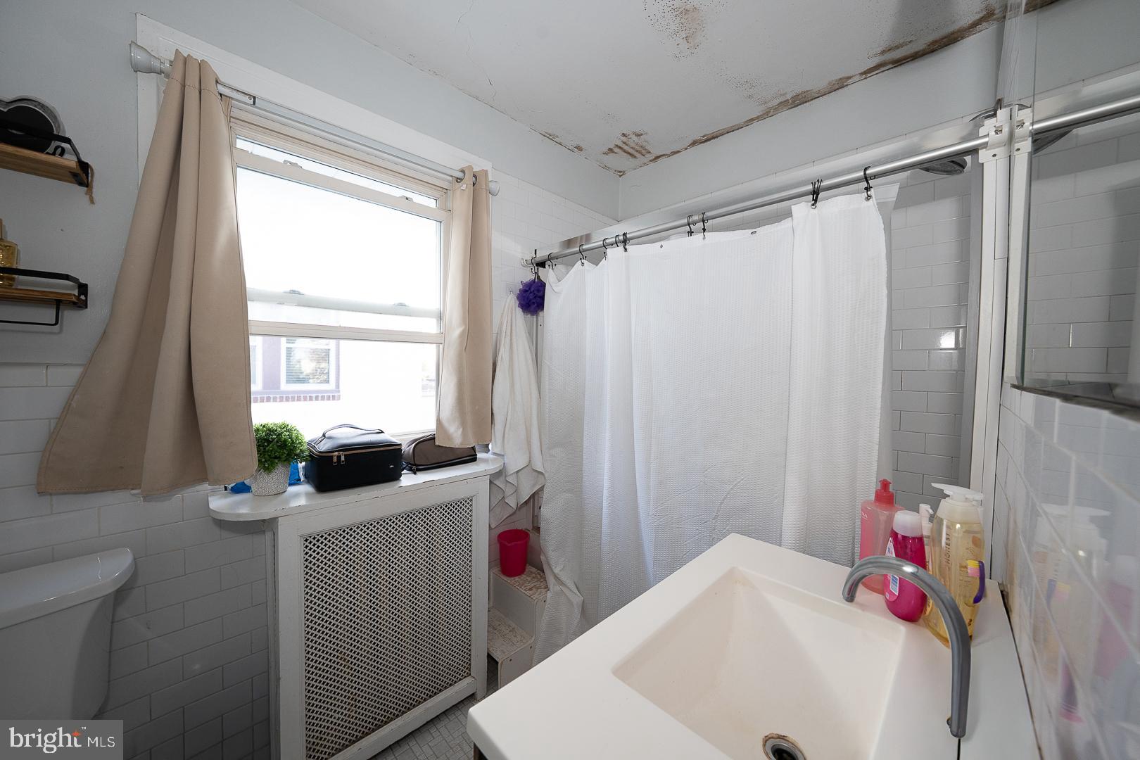 122 Crestview Road Upper Darby, PA 19082 - Photo 29 of 46 a bathroom with a sink a bath tub and a window