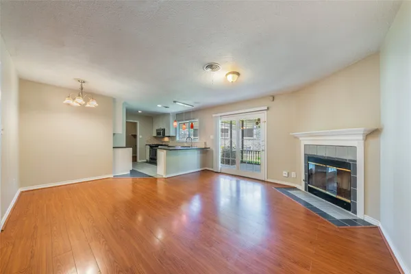 a view of empty room with wooden floor and fireplace