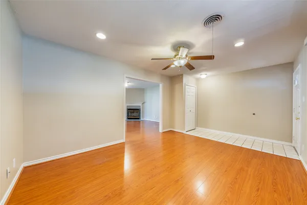 a view of an empty room with a chandelier fan