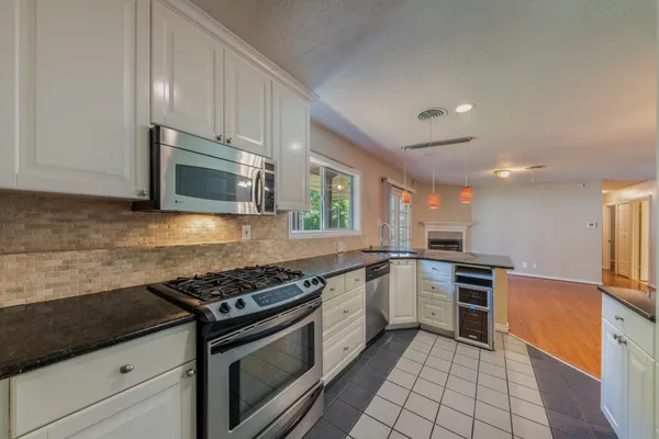a kitchen with stainless steel appliances granite countertop a stove top oven microwave and cabinets