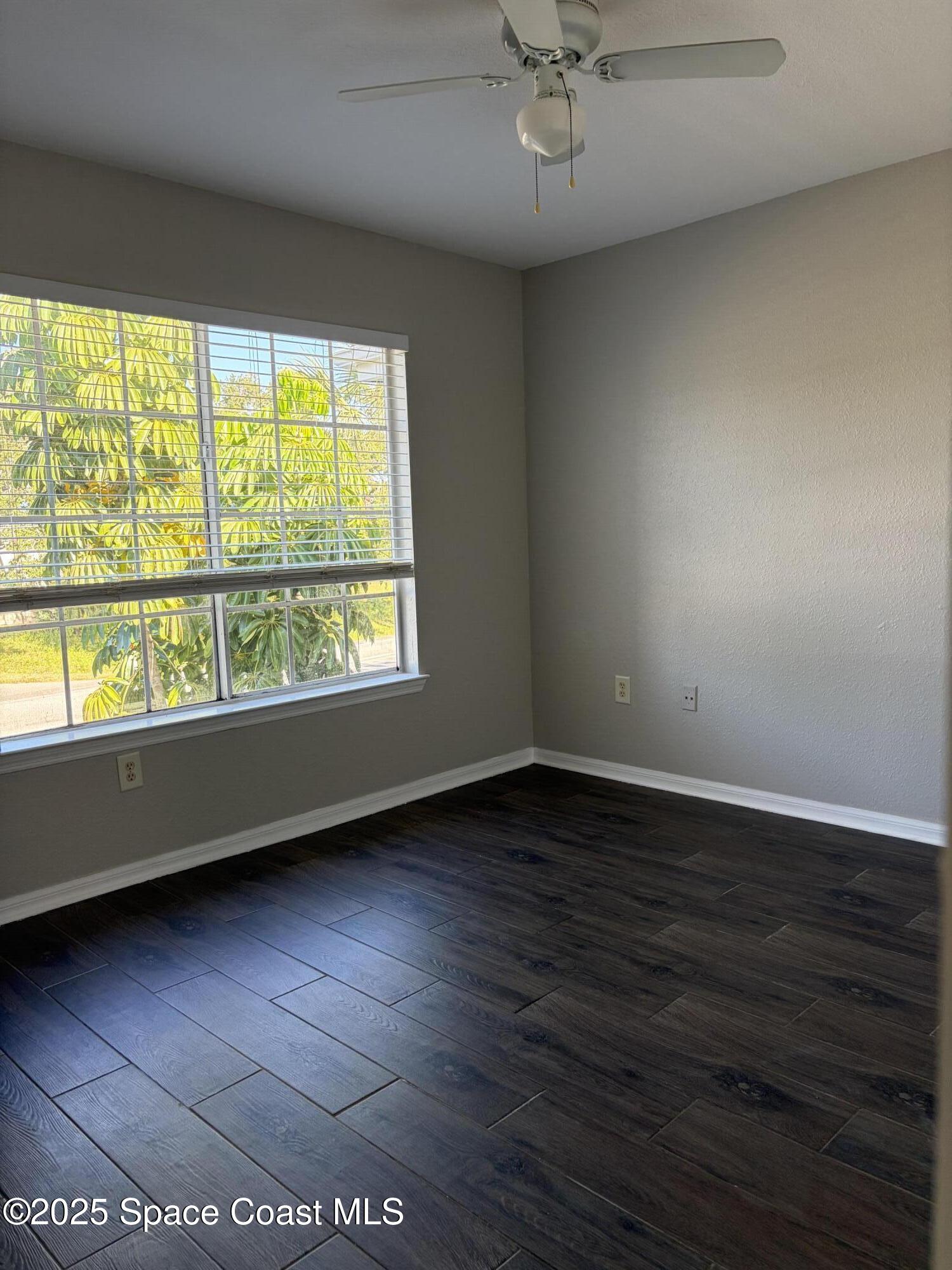 3511 D D'Avinci Way, Unit 2012 Melbourne, FL 32901 - Photo 14 of 26 an empty room with wooden floor and windows