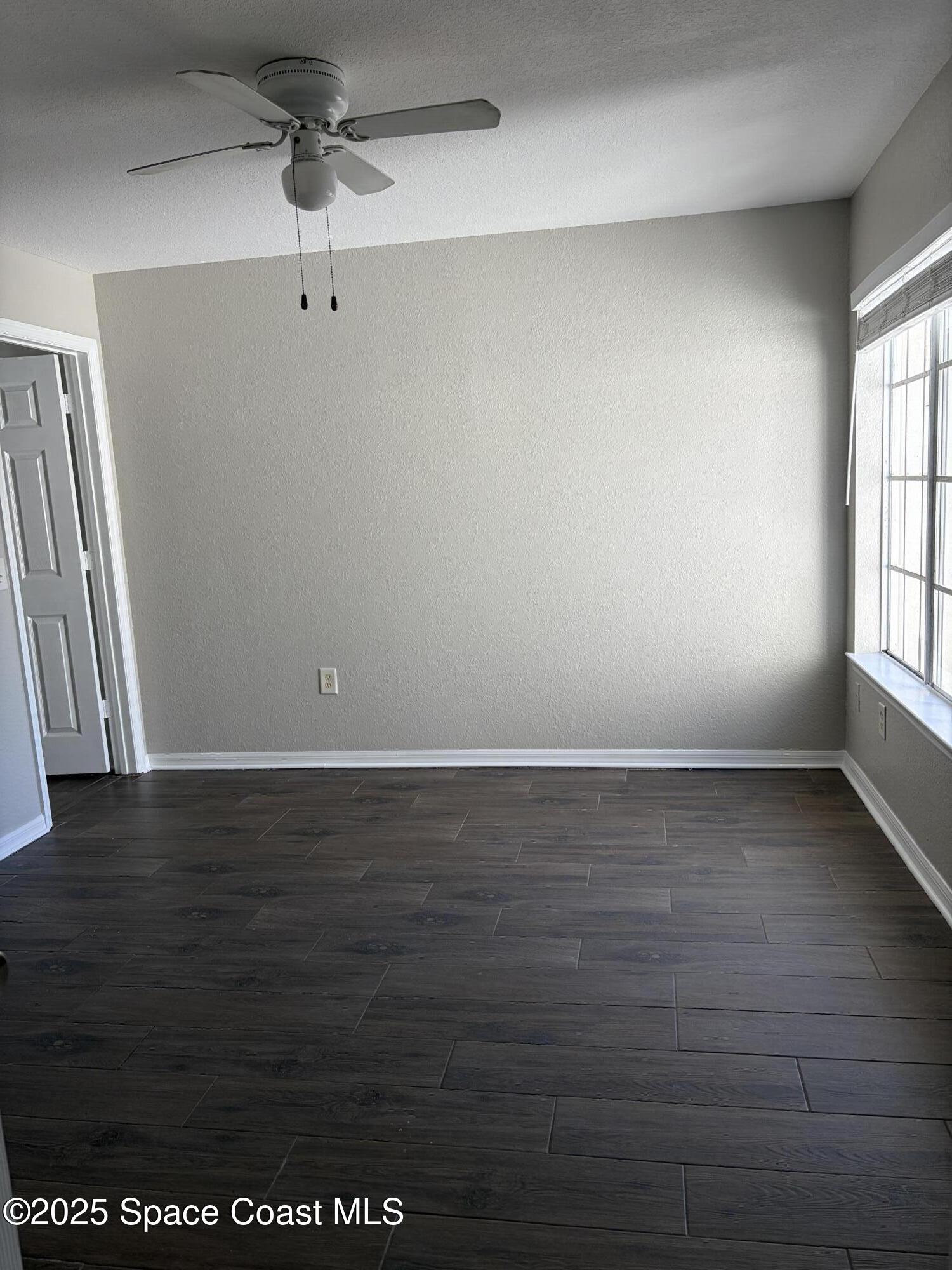 3511 D D'Avinci Way, Unit 2012 Melbourne, FL 32901 - Photo 15 of 26 a view of an empty room with wooden floor and a window
