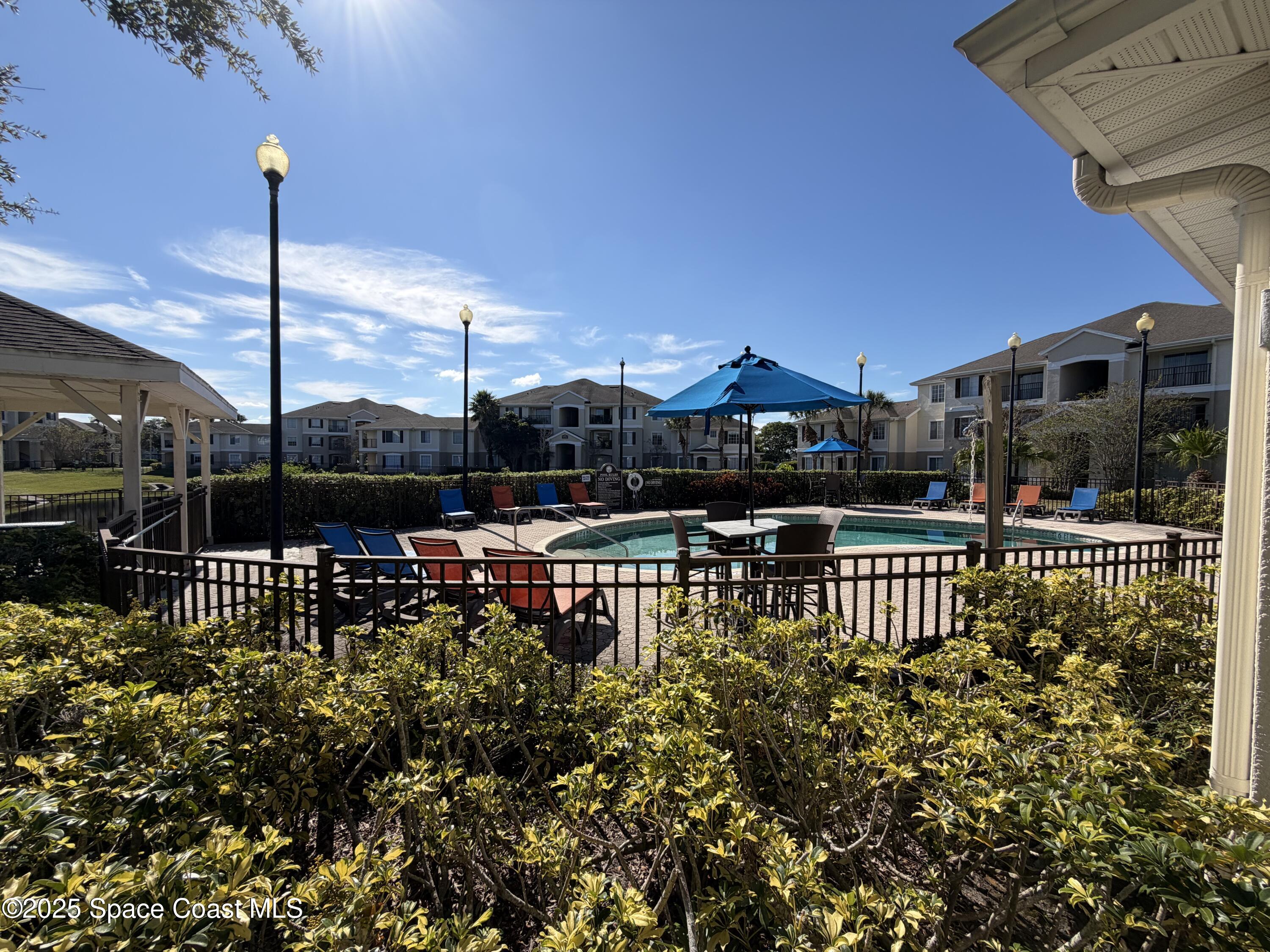 3511 D D'Avinci Way, Unit 2012 Melbourne, FL 32901 - Photo 21 of 26 a view of a chair and tables in the patio