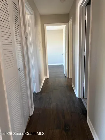 a view of a hallway with wooden floor