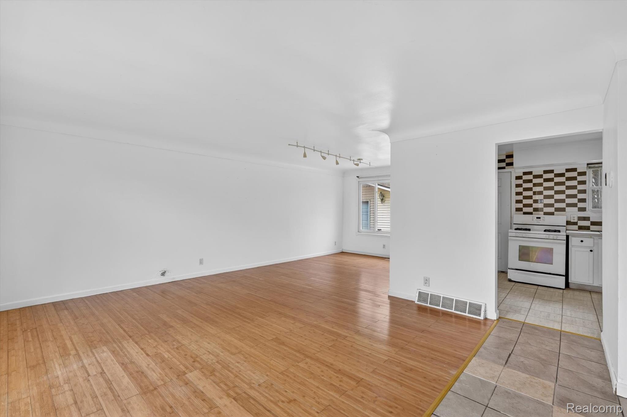 5457 East Frances Road Mount Morris, MI 48458 - Photo 7 of 42 Unfurnished living room featuring light wood finished floors and rail lighting
