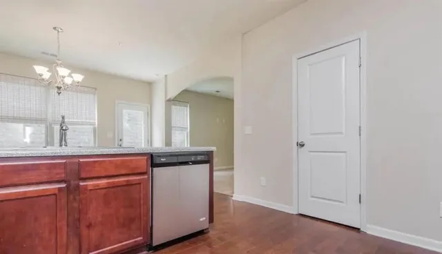 an empty room with windows and chandelier fan