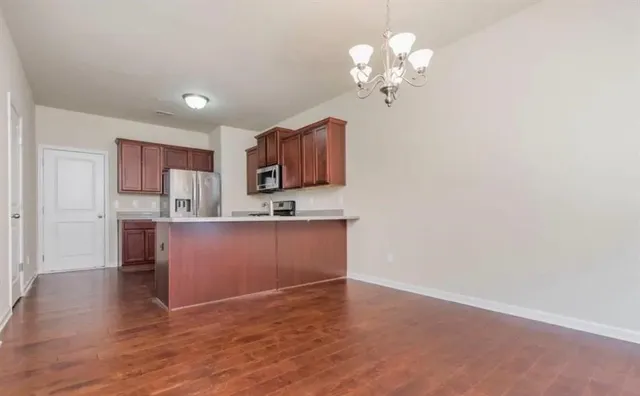 a kitchen with granite countertop a sink cabinets and wooden floor
