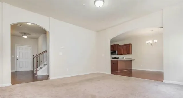an empty room with windows and chandelier