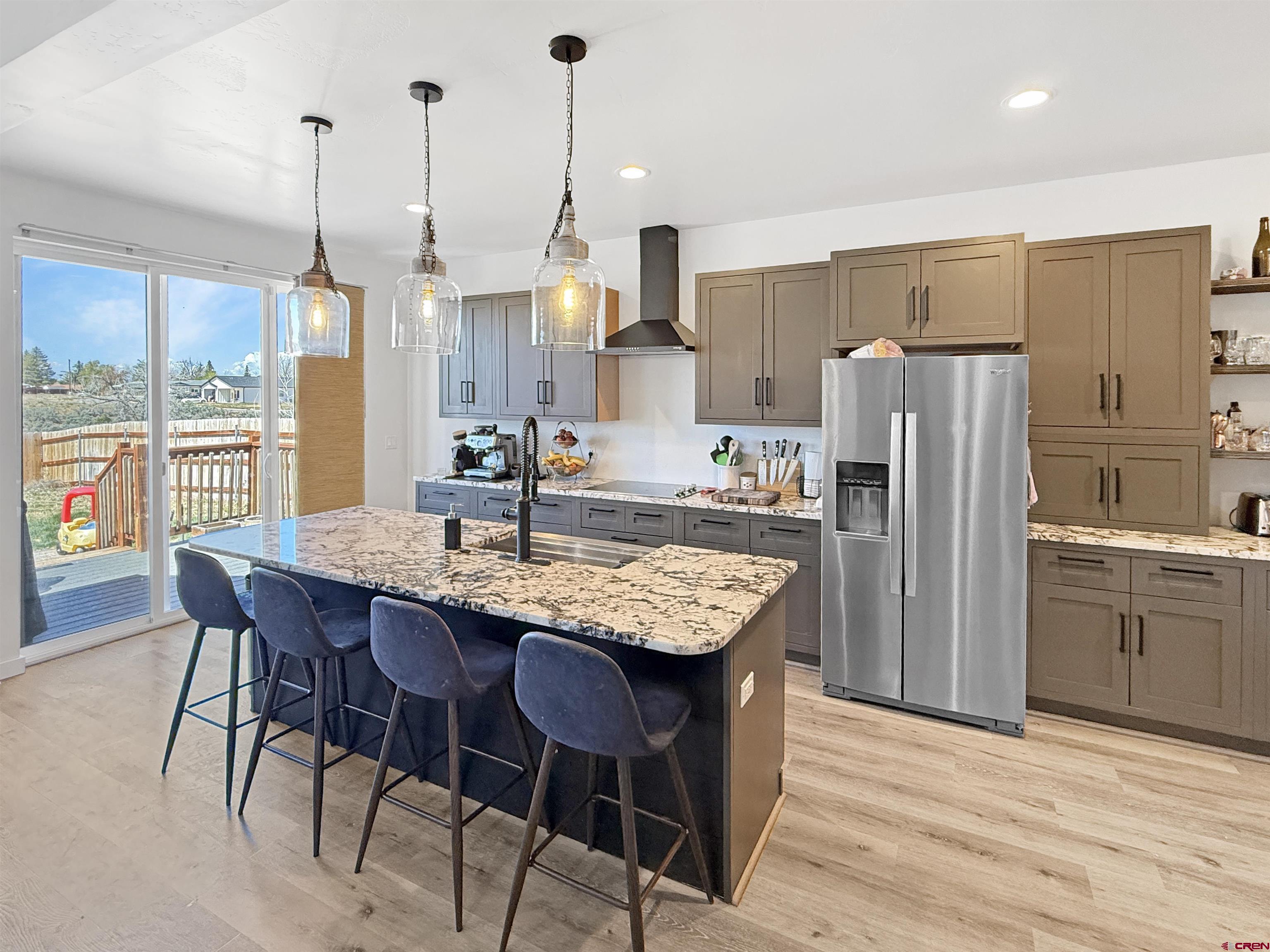 903 South Oak Street Cortez, CO 81321 - Photo 11 of 44 a kitchen with stainless steel appliances granite countertop wooden floor refrigerator and dining table