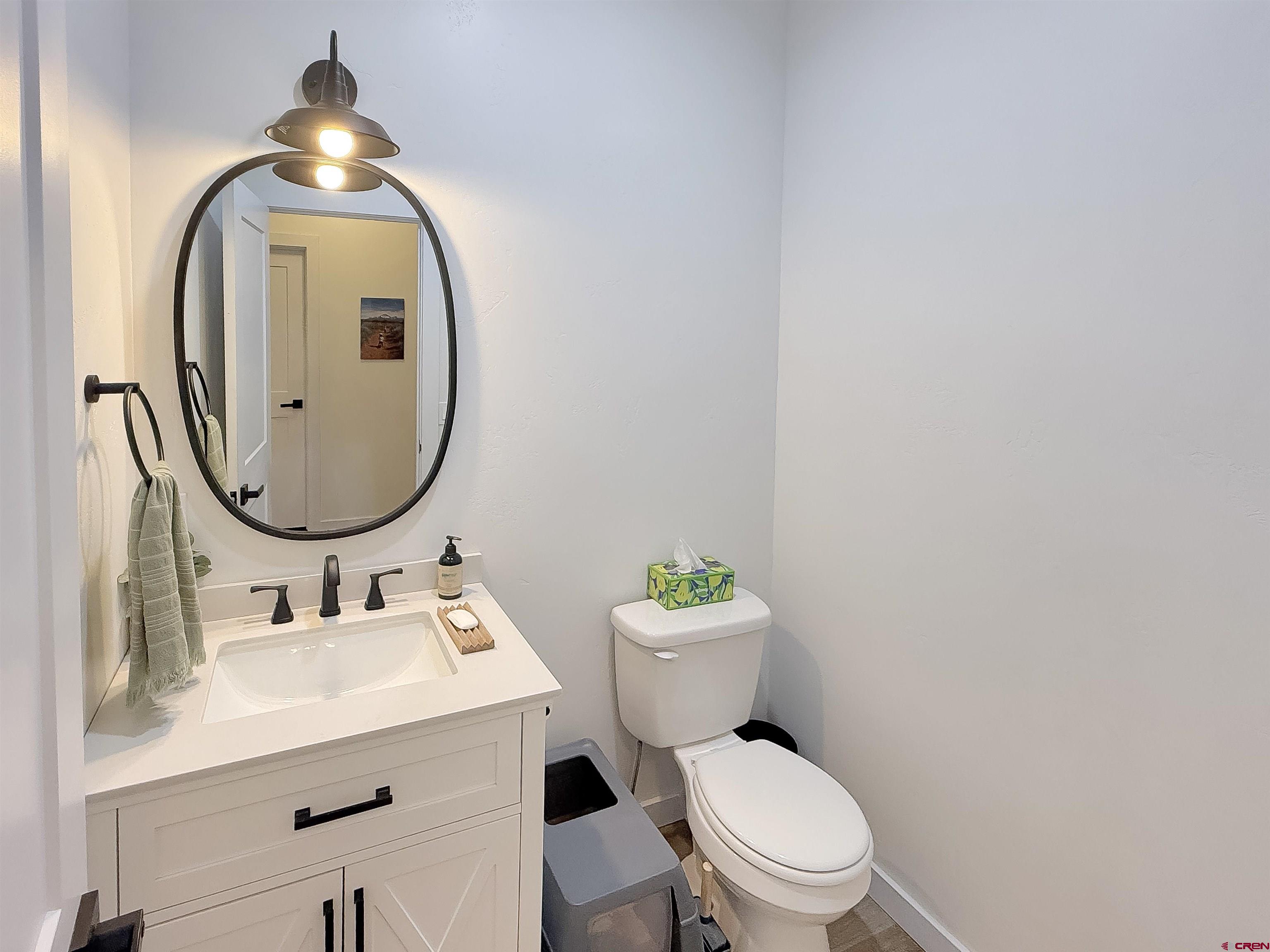 903 South Oak Street Cortez, CO 81321 - Photo 18 of 44 a bathroom with a toilet sink vanity and mirror