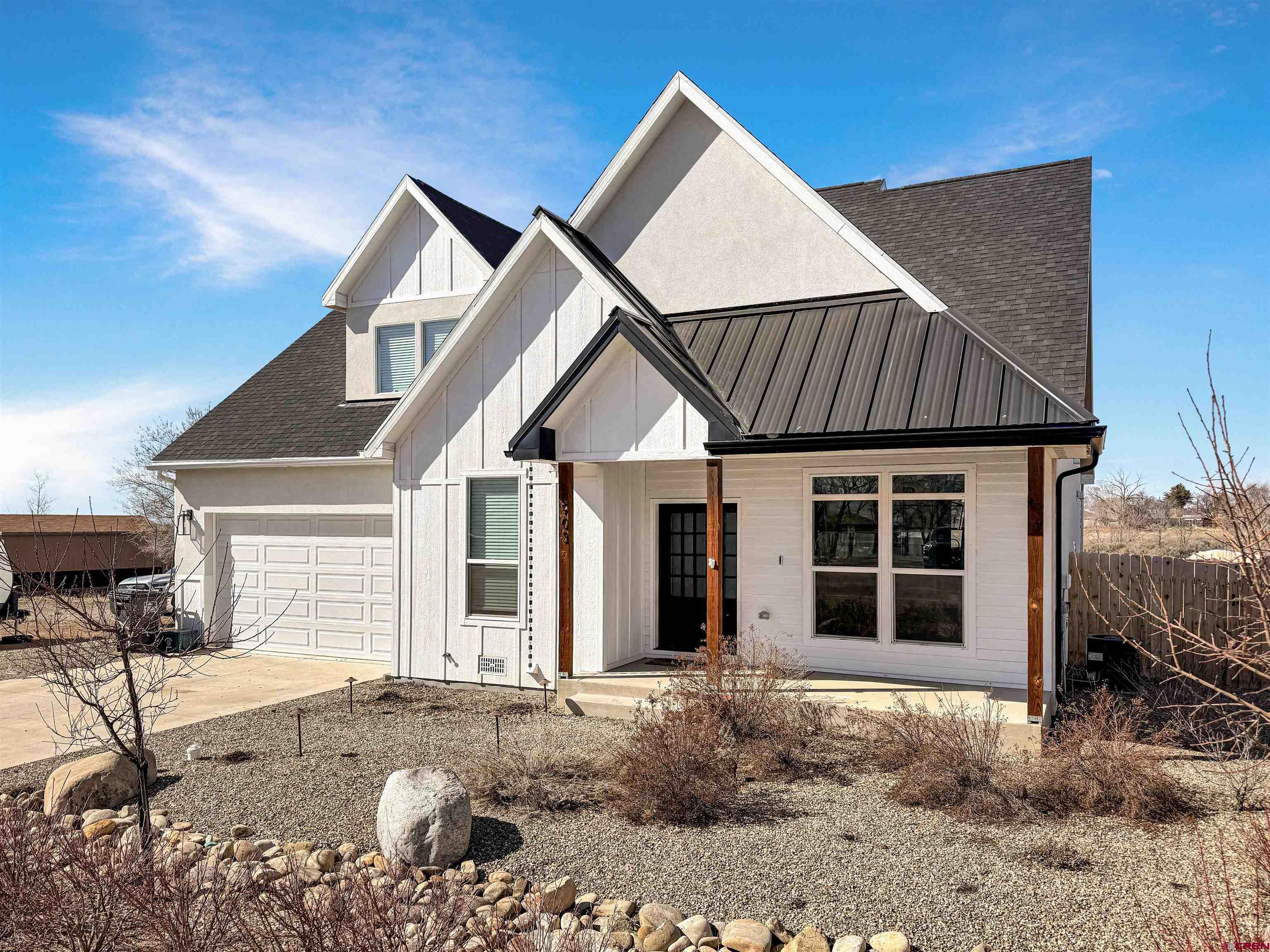 903 South Oak Street Cortez, CO 81321 - Photo 2 of 44 a front view of a house with a yard and garage