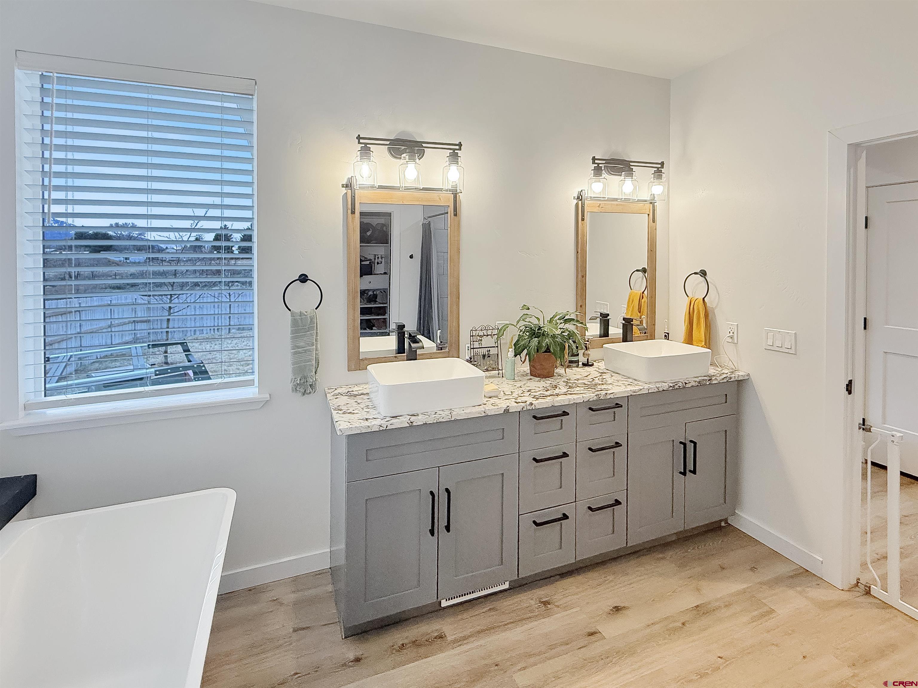 903 South Oak Street Cortez, CO 81321 - Photo 22 of 44 a bathroom with double sink and a mirror