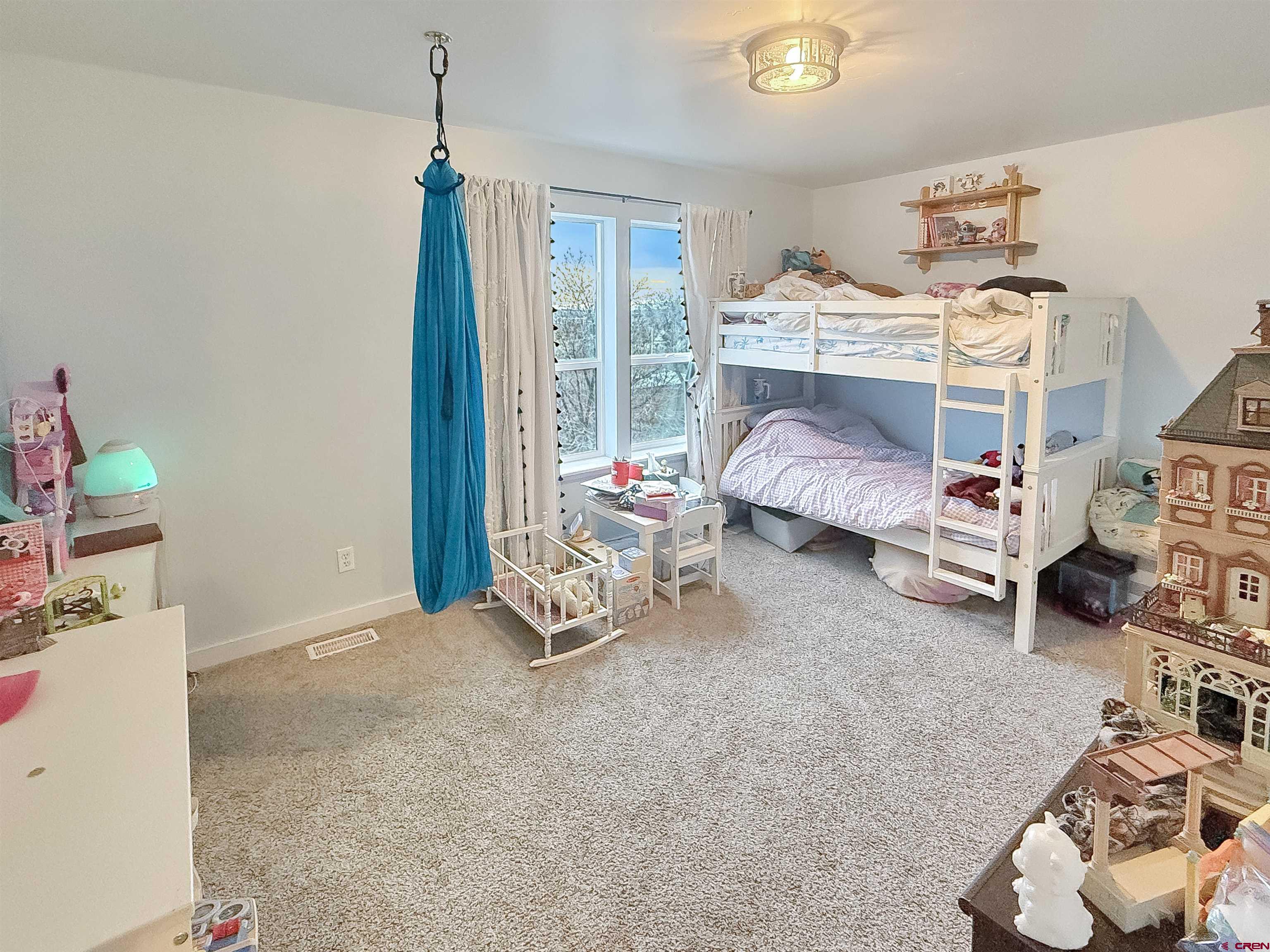 903 South Oak Street Cortez, CO 81321 - Photo 30 of 44 a bedroom with furniture and a chandelier